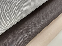 Three rolls of QuietWall Varna Wallpaper by York Wallcoverings, in light gray, dark brown, and beige, are arranged diagonally in parallel. Each wallpaper showcases a woven pattern with a subtle, reflective surface.