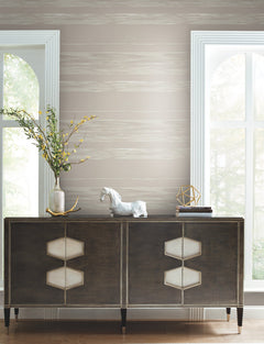 Ronald Redding Horizontal Dry Brush Wallpaper featuring horizontal, dry-brushed stripes in shades of gray and white behind a dark wood cabinet.