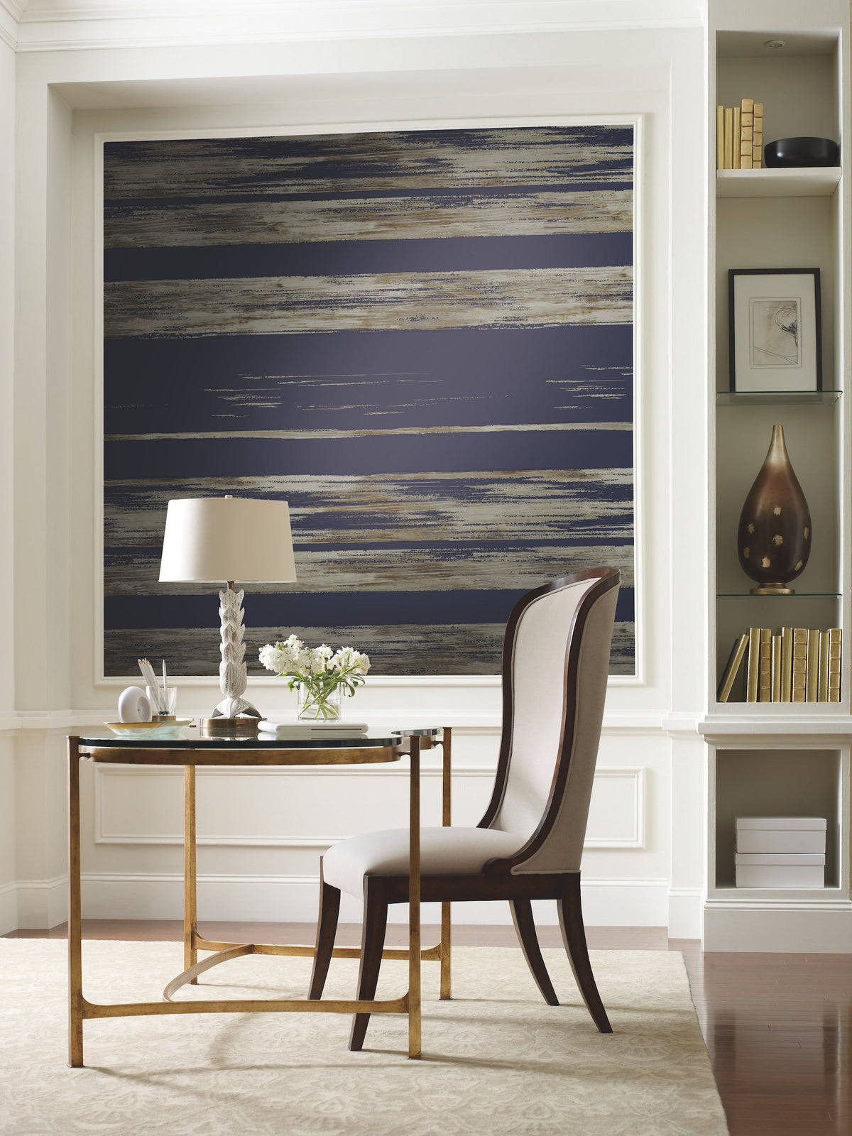 Ronald Redding Horizontal Dry Brush Wallpaper with horizontal dry brush stripes in dark blue, brown, and metallic tones installed on a wall behind a writing desk.
