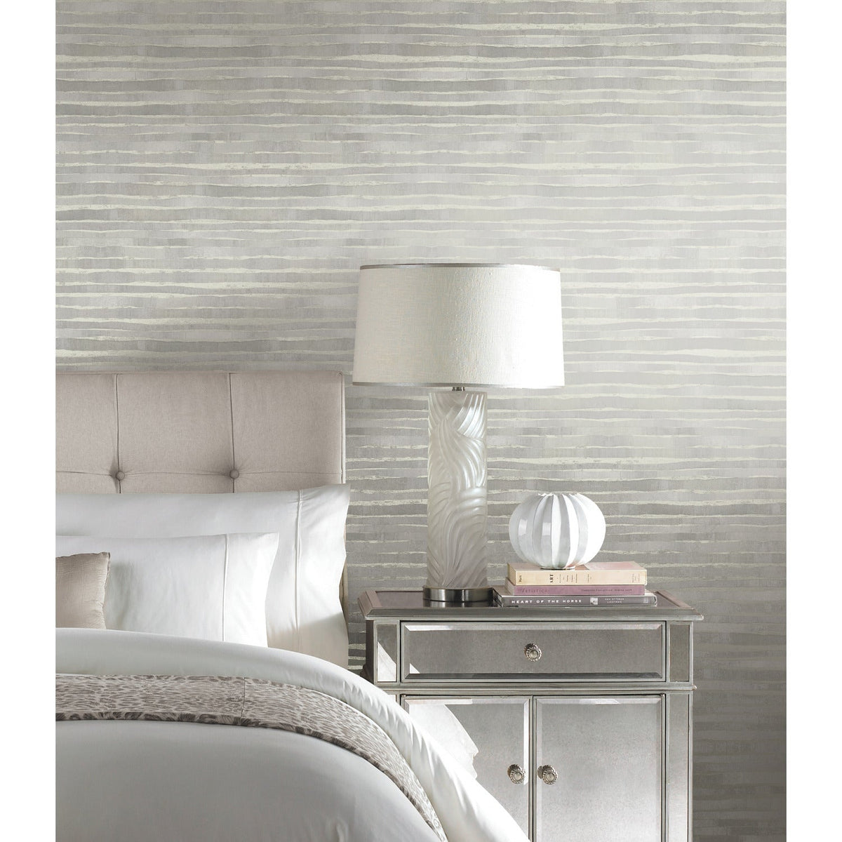 Ronald Redding Dreamscapes Wallpaper in a bedroom features a pattern of horizontal, layered brushstrokes in shades of grey and white.