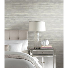 Ronald Redding Dreamscapes Wallpaper in a bedroom features a pattern of horizontal, layered brushstrokes in shades of grey and white.