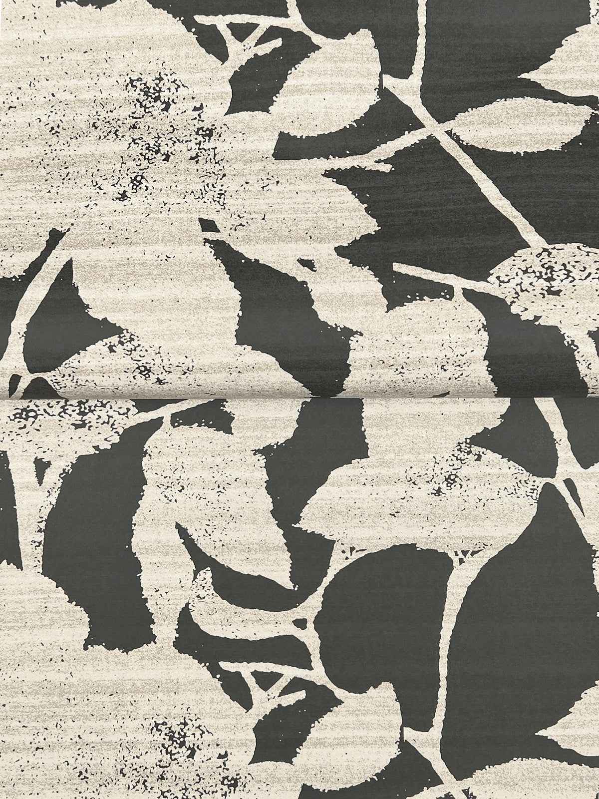 Solange Botanical Wallpaper by York Wallcoverings showcases a bold black and white abstract pattern of large, overlapping leaves and floral motifs with textured shading, arranged across a visible central seam.