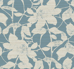 Solange Botanical Wallpaper by York Wallcoverings features a blue background adorned with large, off-white textured leaves and flowers. The vintage-inspired botanical design showcases overlapping and intertwining outlines, creating an elegant and timeless look.