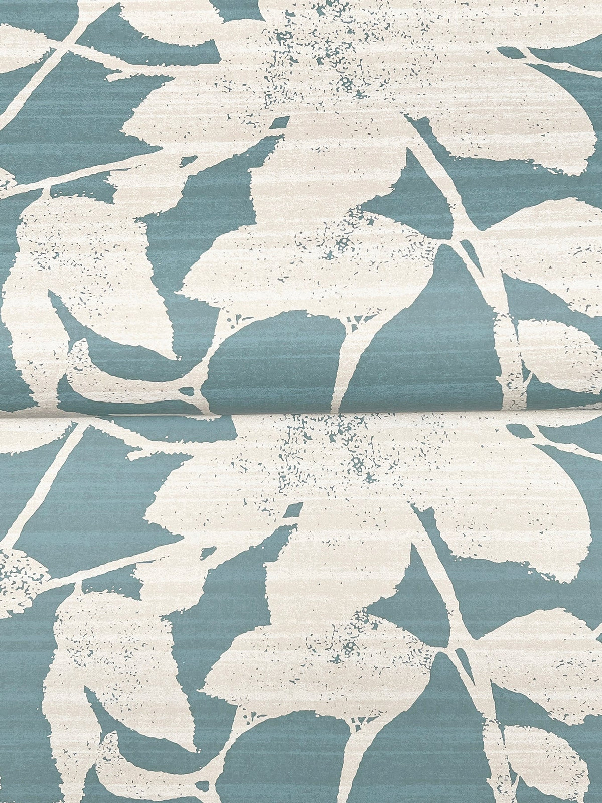 The Solange Botanical Wallpaper by York Wallcoverings features a large, abstract leaf pattern in blue and cream. Its design has a textured look, with a visible horizontal seam where two wallpaper panels meet.