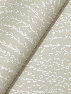 Willow Song Botanical Wallpaper by York Wallcoverings, shown rolled out at an angle, features a subtle white botanical pattern of delicate branches and leaves on a beige background.