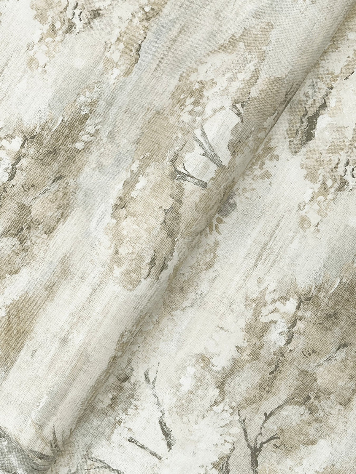 Moreno Woodland Wallpaper by York Wallcoverings features beige and taupe hues with a subtle, painterly pattern of trees and foliage, creating a soft, natural, and textured look.