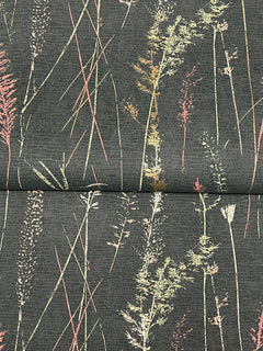 The Meadow Splendor Botanical Wallpaper showcases a dark background adorned with tall, delicate grasses in subtle shades of pink, yellow, and green for a natural, botanical effect. A horizontal seam is visible across the center.