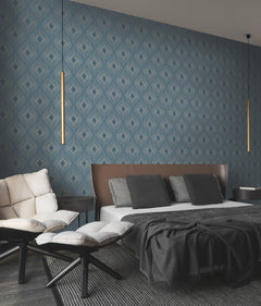 Modern bedroom featuring Harlowe Wallpaper by York Wallcoverings in a geometric blue pattern, a low bed with brown headboard, black and white bedding, cushioned chairs, and two slim pendant lights hanging from the ceiling.