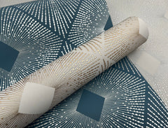 A close-up of the Harlowe Wallpaper by York Wallcoverings, showcasing its geometric pattern with metallic gold lines radiating from square shapes on a blue and white background.