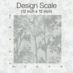 A 12 inch by 12 inch square of Shimmering Foliage Wallpaper by York Wallcoverings displays a muted, abstract tree branch pattern, with a ruler on the left and bottom edges indicating inches, and the text “Design Scale (12 inch x 12 inch)” at the top.