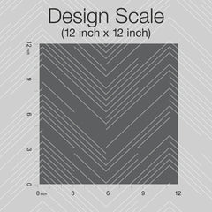 A 12 inch x 12 inch gray square featuring white chevron lines, representing the York Wallcoverings Polished Chevron Wallpaper, is displayed centered on a patterned background. Inch rulers run along the top and left edges, accompanied by text reading “Design Scale (12 inch x 12 inch).”.