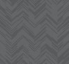 The Polished Chevron Wallpaper by York Wallcoverings features a repeating chevron design composed of thin white lines set against a dark gray background, producing a striking zigzag effect throughout the pattern.
