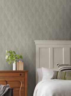 Magnolia Home Challenger Wallpaper with a grey, subtle herringbone pattern behind a wooden nightstand and a bed with a white headboard.
