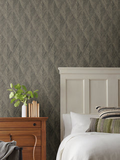 Magnolia Home Challenger Wallpaper with a dark, textured diamond pattern on a wall behind a bed and wooden nightstand.