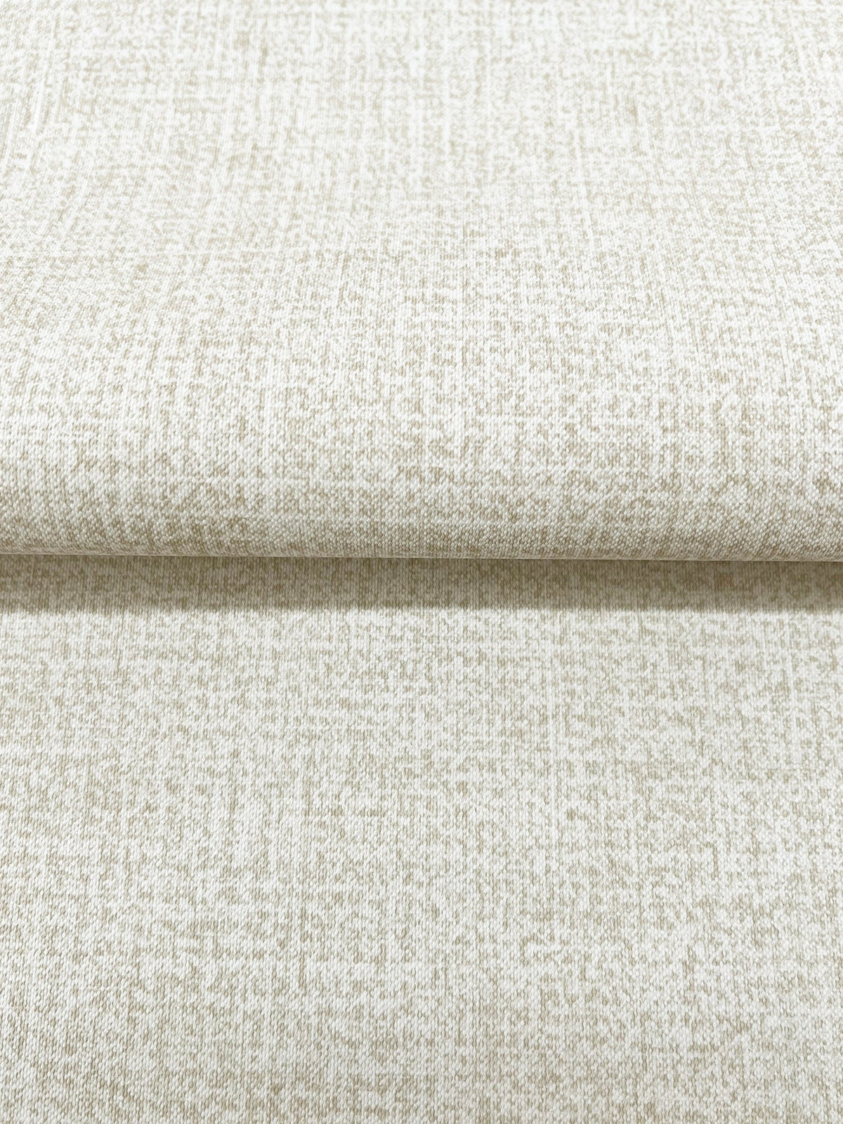 A roll of neutral Magnolia Home Brindled Wallpaper featuring a fine, brindled texture.