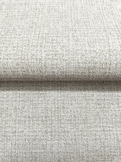 Close-up of a roll of Magnolia Home Brindled Wallpaper in tan with a mottled, textured pattern.