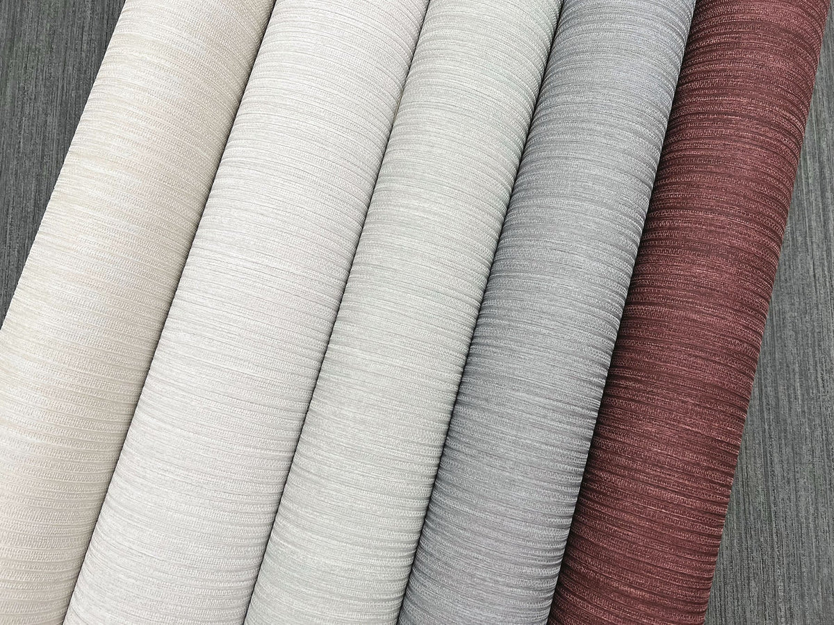 Five rolls of Smooth as Silk Wallpaper in shades of cream, gray, and dark red arranged side by side.