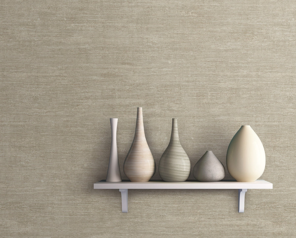 A white shelf holds five decorative vases of varying shapes and neutral tones, displayed against a Heathered Wool Wallpaper by York Wallcoverings in textured beige.