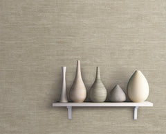 A white shelf holds five decorative vases of varying shapes and neutral tones, displayed against a Heathered Wool Wallpaper by York Wallcoverings in textured beige.