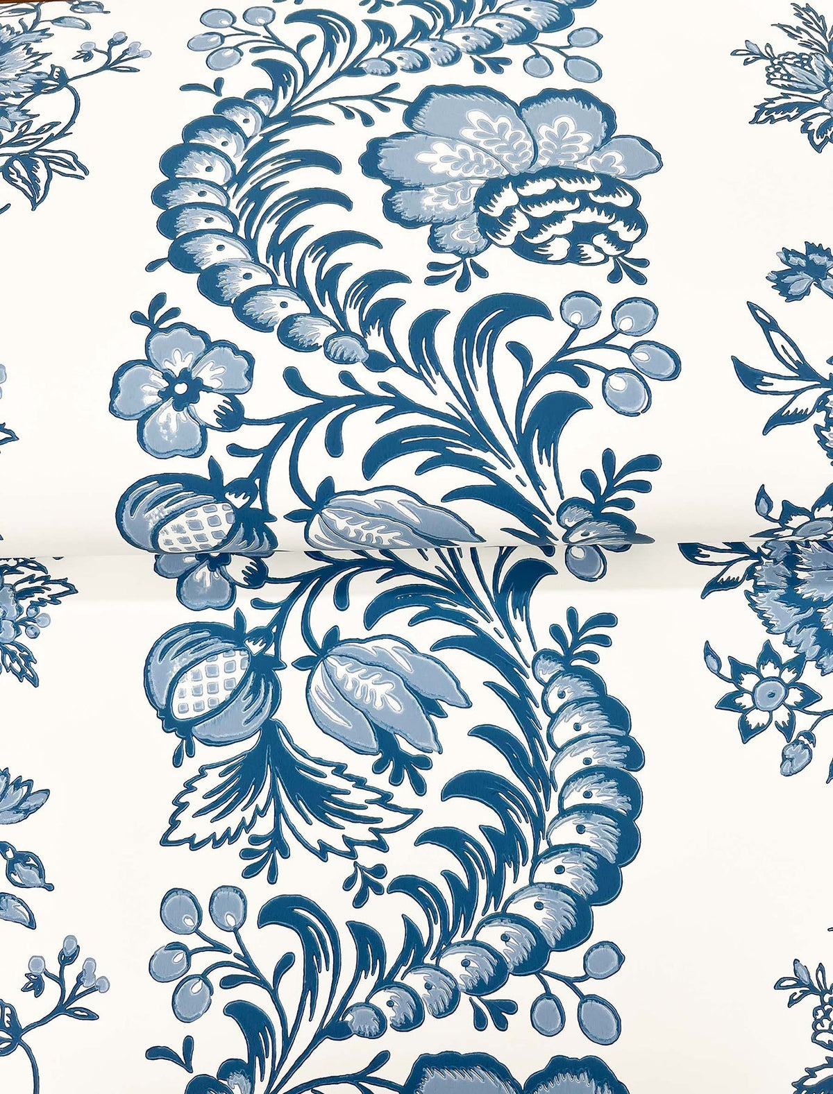 Beaumont Floral Stripe Wallpaper by York Wallcoverings features a blue floral and leaf pattern on a white background, with stylized flowers, leaves, and berries arranged in a flowing, decorative design.