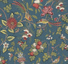 The Parterre Jacobean Wallpaper by York Wallcoverings showcases colorful birds perched on leafy branches, adorned with red, white, and yellow flowers and fruit clusters, all set against a muted blue background.