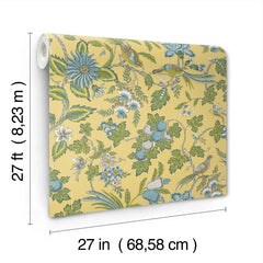 Parterre Jacobean Wallpaper by York Wallcoverings features a yellow background with a floral and bird pattern in green, blue, and white. Each roll measures 27 feet (8.23 m) long and 27 inches (68.58 cm) wide.