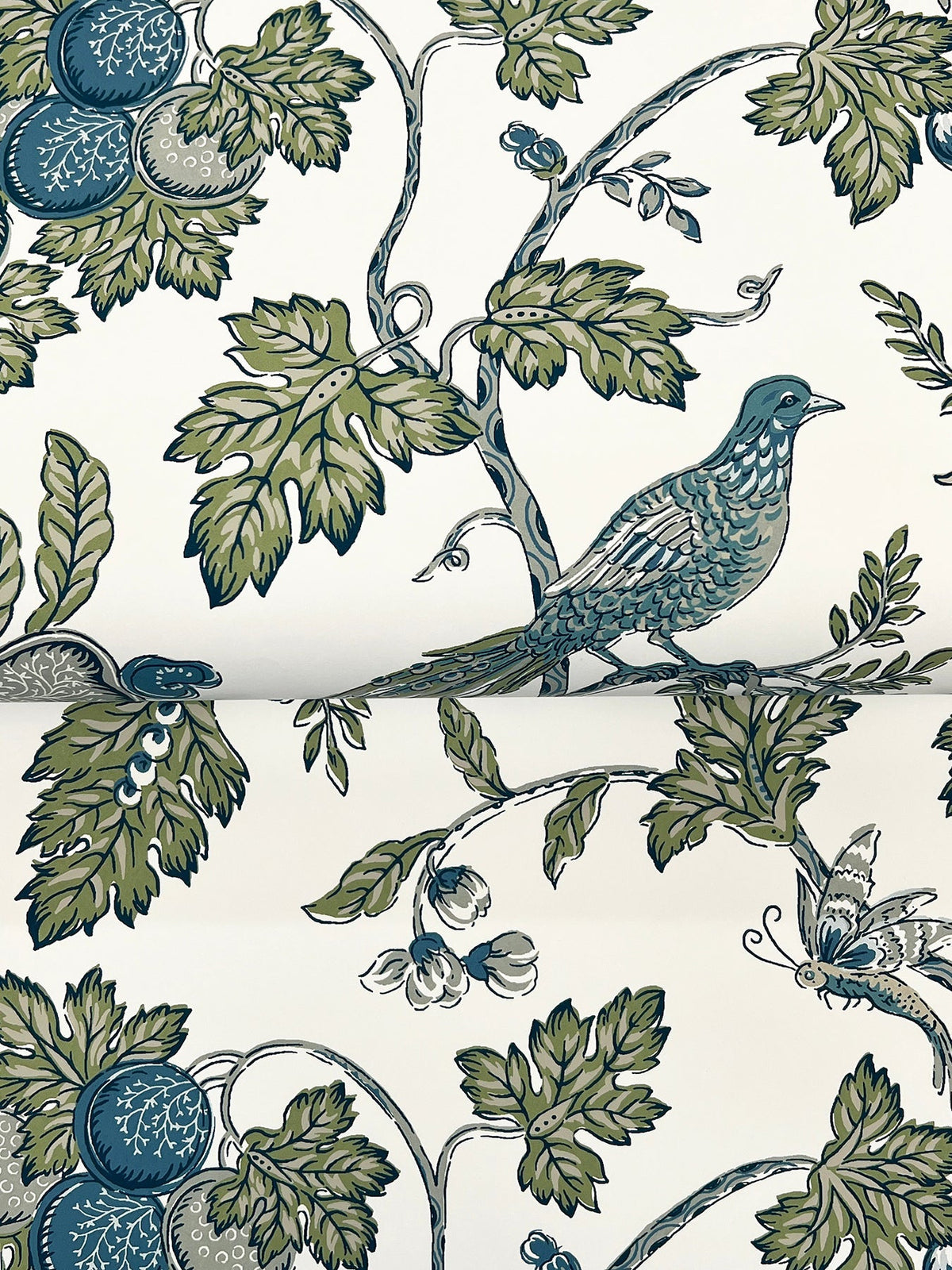 The Parterre Jacobean Wallpaper by York Wallcoverings features a detailed, vintage-inspired pattern of leafy branches, blue-green birds, fruits, and butterflies set against a white background.