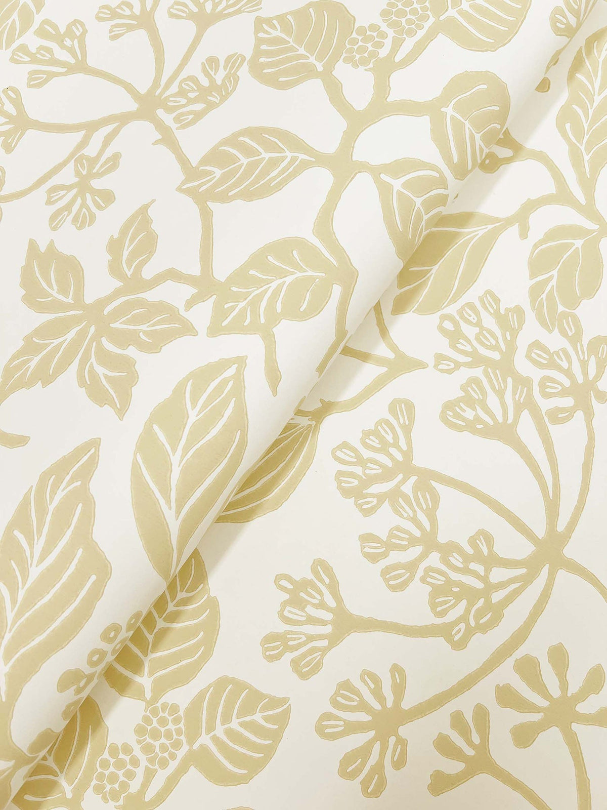 Rowen Botanical Wallpaper by York Wallcoverings showcases a seamless design of gold leaves, branches, and delicate berries on a cream-colored background. The slightly folded wallpaper reveals how the elegant botanical pattern continues fluidly across the surface.