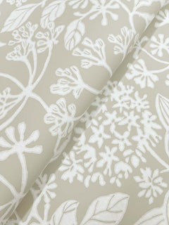 Rowen Botanical Wallpaper by York Wallcoverings features a beige background adorned with a white, hand-drawn floral and leaf pattern of delicate branches and stylized blossoms.