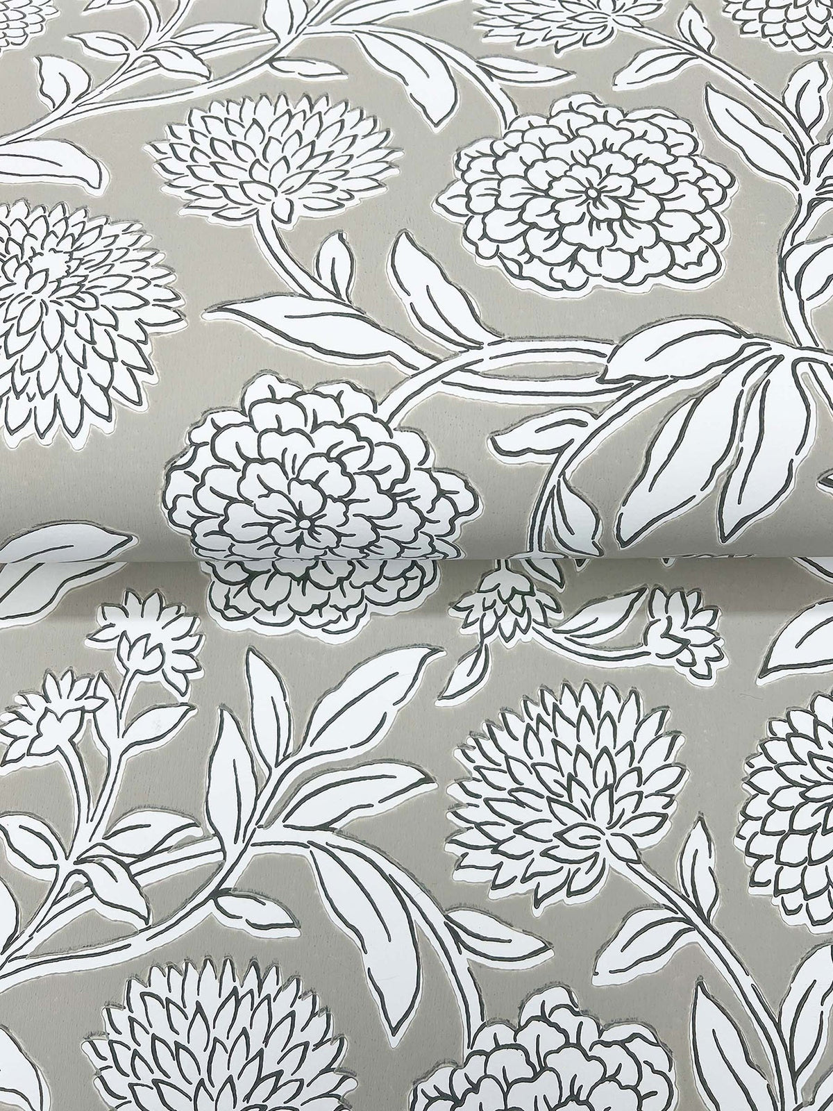 Chatsworth Garden Floral Trail Wallpaper by York Wallcoverings features a gray background adorned with a white floral pattern of large blooming flowers and intricately outlined leaves. The detailed design repeats across the surface, creating a gentle sense of depth with subtle folds and overlapping elements.