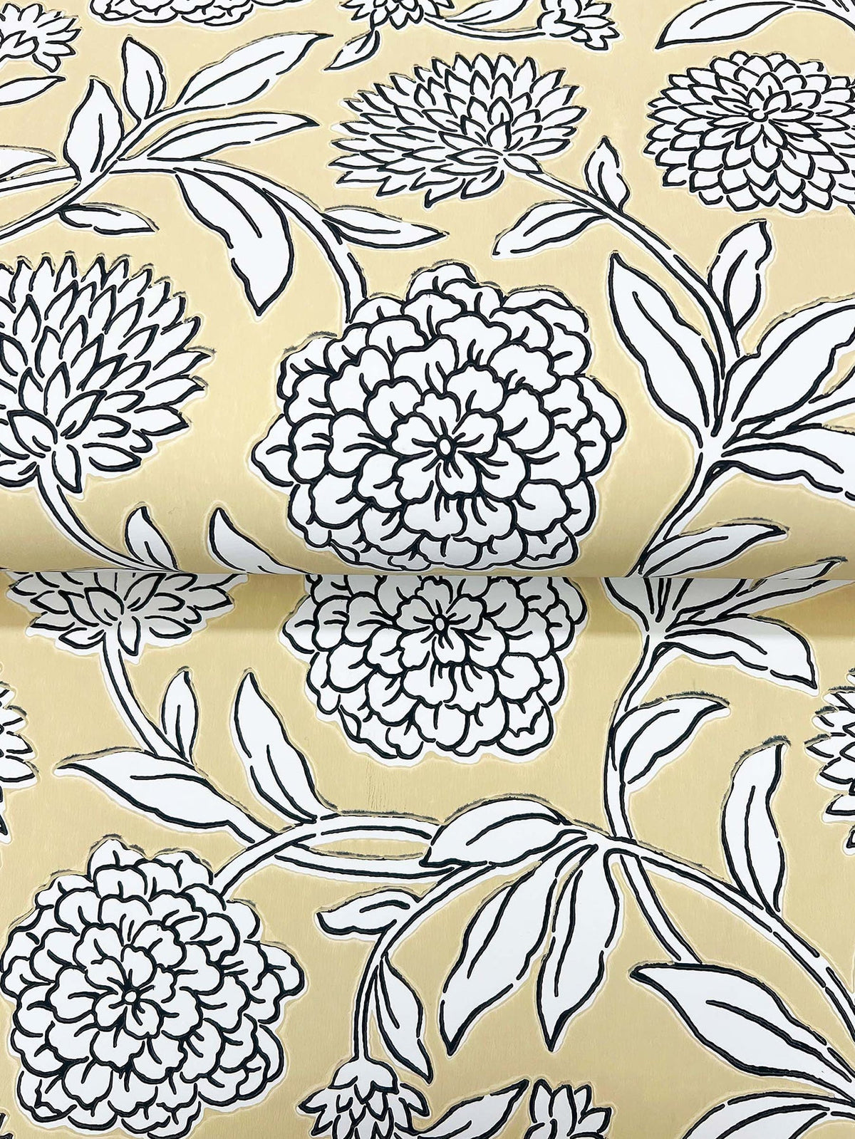 The image displays a roll of Chatsworth Garden Floral Trail Wallpaper by York Wallcoverings, featuring a yellow background adorned with large, detailed black and white floral motifs and leafy stems.
