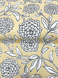 The image displays a roll of Chatsworth Garden Floral Trail Wallpaper by York Wallcoverings, featuring a yellow background adorned with large, detailed black and white floral motifs and leafy stems.