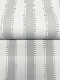 A close-up of the Tilford Awning Stripe Wallpaper by York Wallcoverings, featuring vertical gray and white stripes bordered by small, repeating diamond and dot patterns. The wallpaper is shown partially unrolled on a flat surface.