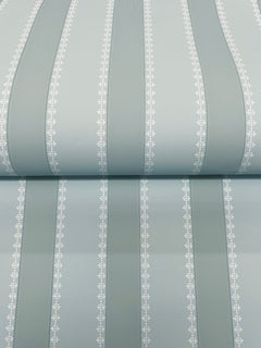 The Tilford Awning Stripe Wallpaper by York Wallcoverings features pale blue vertical stripes in varying widths, separated by thin white lines adorned with a small repeating leaf pattern. The wallpaper is shown rolled out on a flat surface.