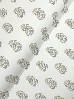 Sylvie Floral Wallpaper by York Wallcoverings features a white background adorned with a repeating pattern of grey leaves and muted yellow flowers; the wallpaper is shown with a visible diagonal crease across the center.