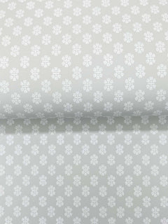 The Brioni Floral Stamp Wallpaper by York Wallcoverings features a light grey backdrop adorned with a subtle, repeating pattern of small white four-petaled flowers, creating a soft, delicate, and uniform appearance across the surface.