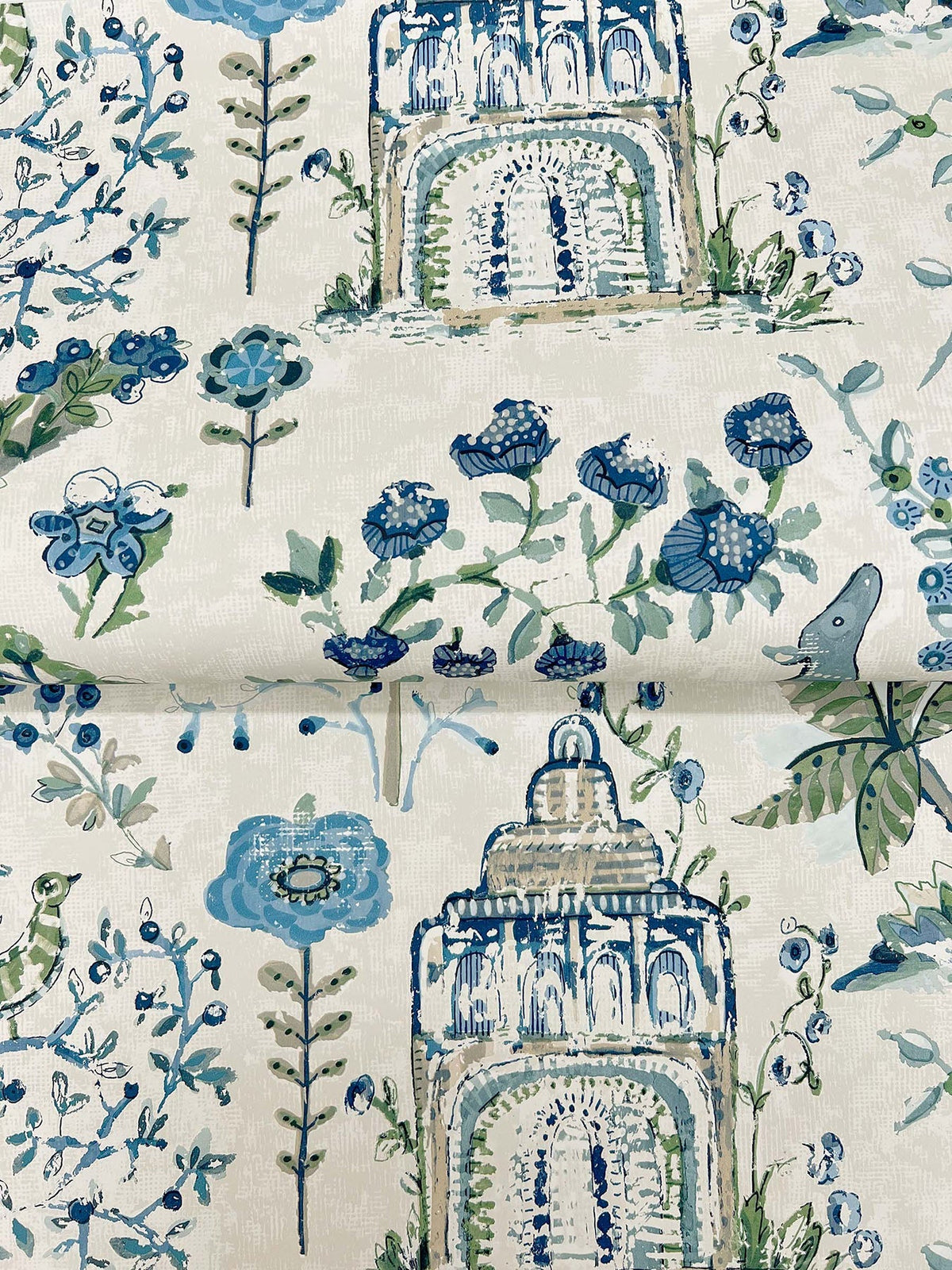 Parc Garden Dreams Wallpaper by York Wallcoverings features a whimsical blue and green floral pattern with stylized flowers, leafy accents, and ornate architectural arches set against a light background.