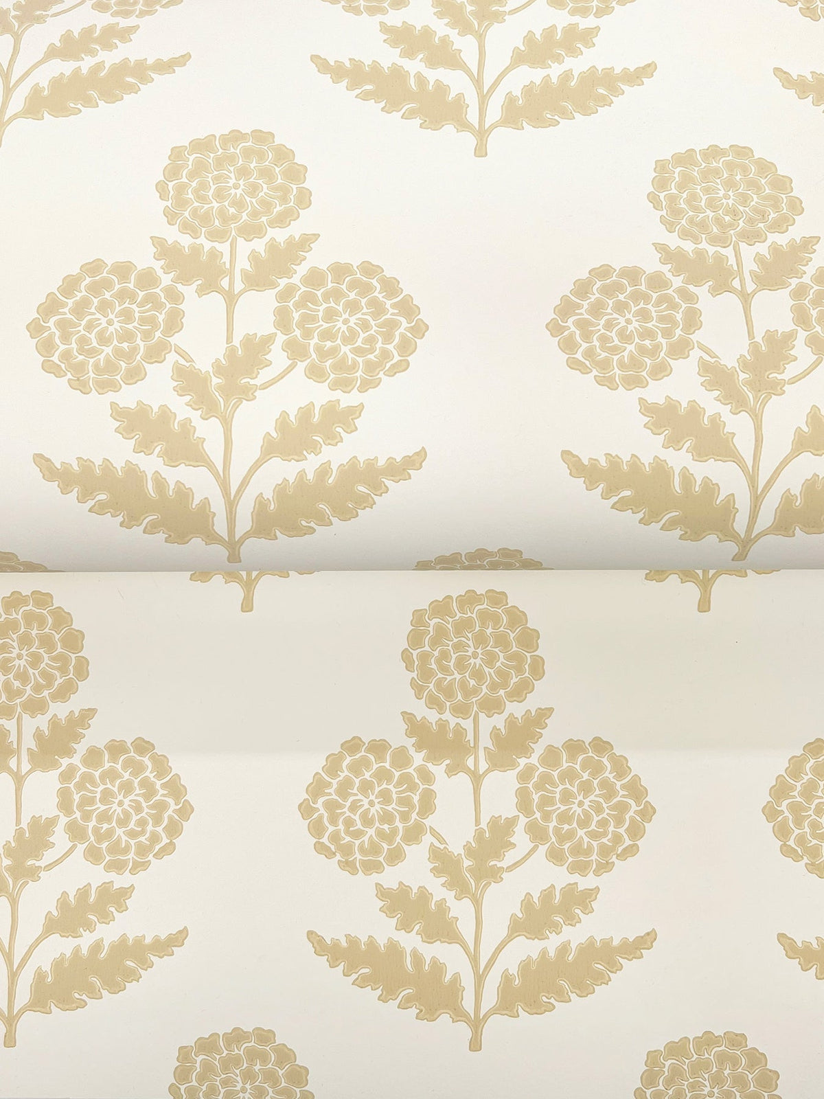 The Souci Marigolds Wallpaper by York Wallcoverings features a beige floral pattern with stylized flowers and leaves, repeated symmetrically and evenly spaced on a light cream background for a classic, elegant look.