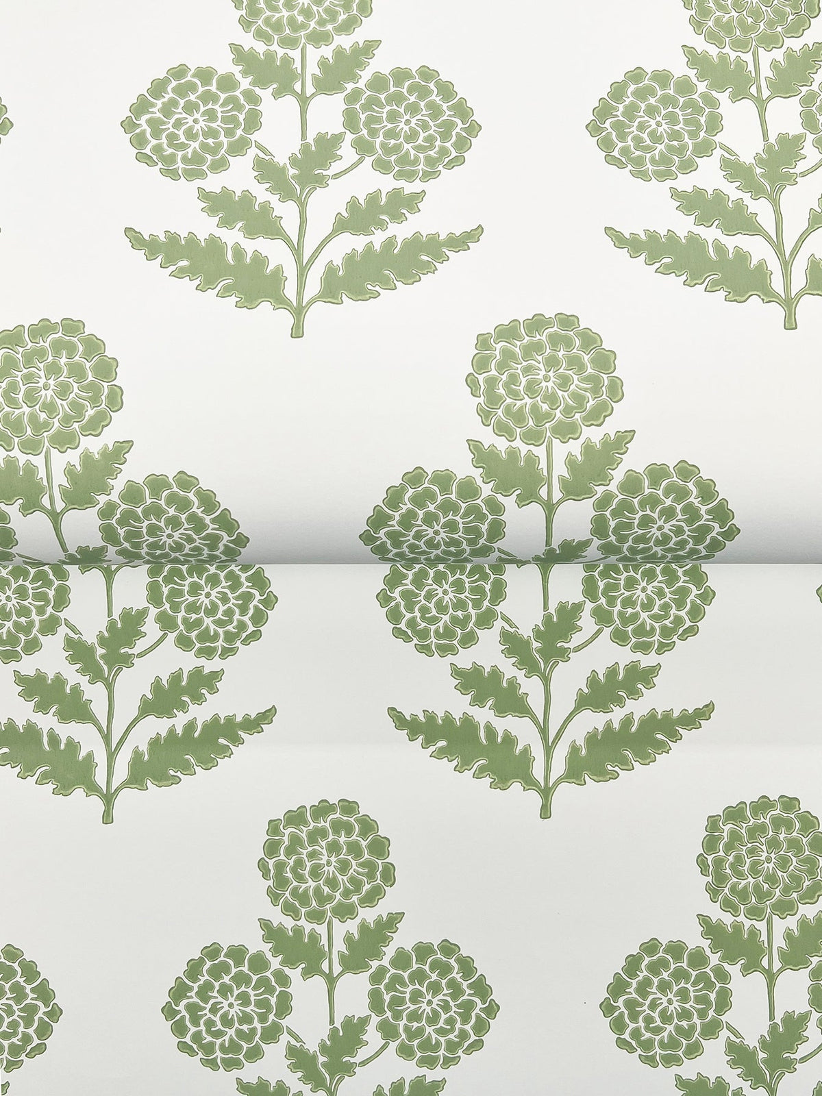The Souci Marigolds Wallpaper by York Wallcoverings features a green floral pattern on a white background, showcasing stylized marigold flowers with round clusters of petals and intricately detailed leaves arranged in a symmetrical, repeating design.