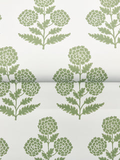 Souci Marigolds Wallpaper by York Wallcoverings features a green floral pattern with stylized marigold flowers, each displaying round clusters of petals and leafy stems, all arranged in a repeating, symmetrical design on a white background. The wallpaper is shown partially rolled out.